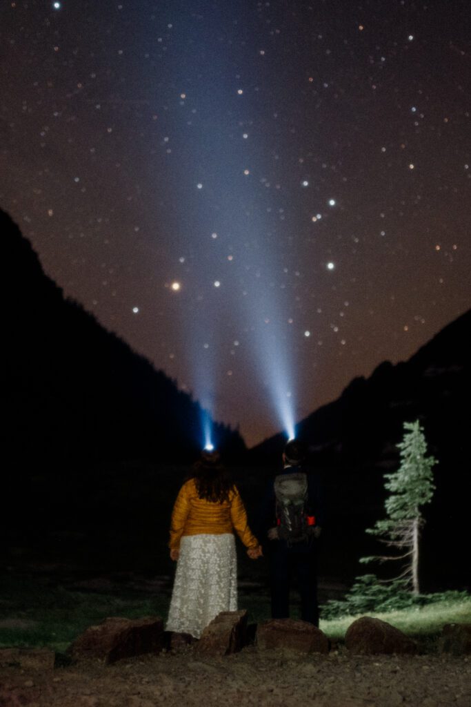 Couple walking with headlamps as they stargaze at a national park. 