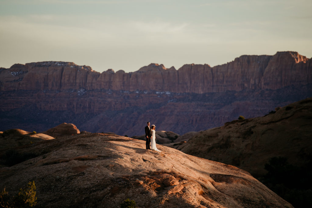The best desert elopement location is Moab, Utah. You can get married in the dessert under the stars. Canyons and pink sunsets with bride and groom. 