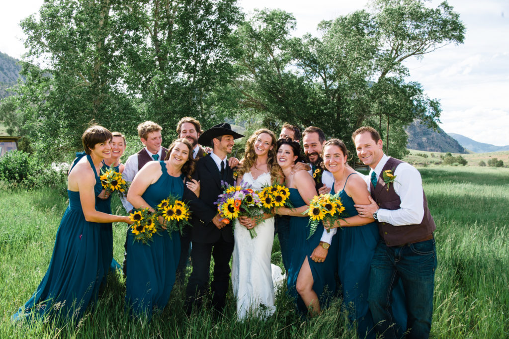 full wedding party with green bridesmaids dresses and sunflowers Yellowstone National Park Wedding