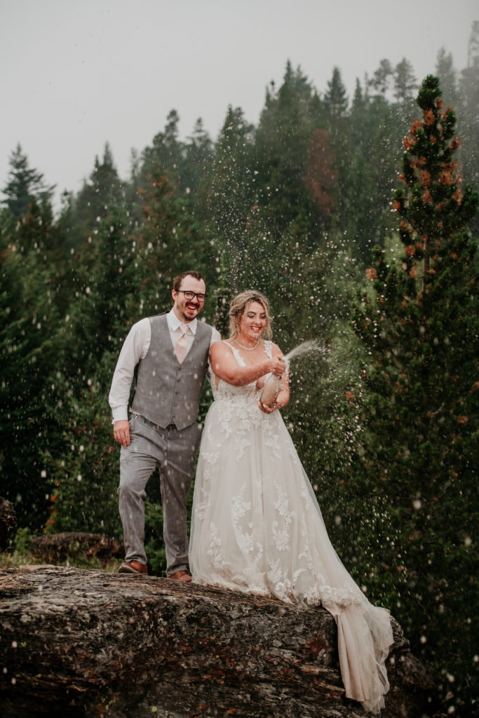 Glacier National Park Elopement at Saint Mary, bride and groom popping champagne