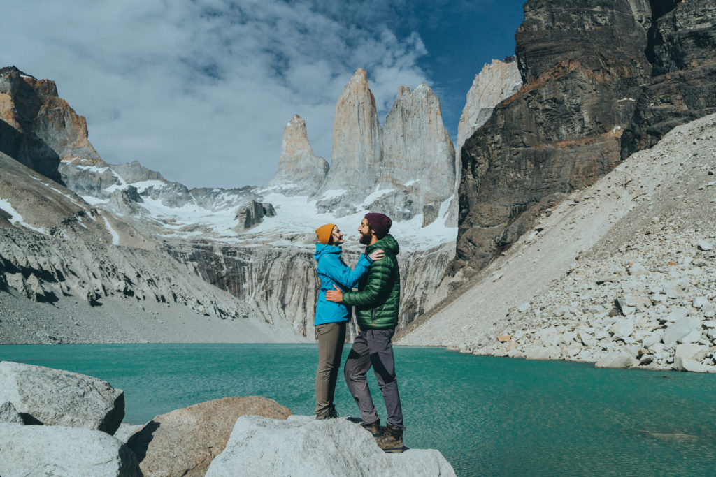 Young Caucasian heterosexual couple  standing on the background of Torres del Paine National Park