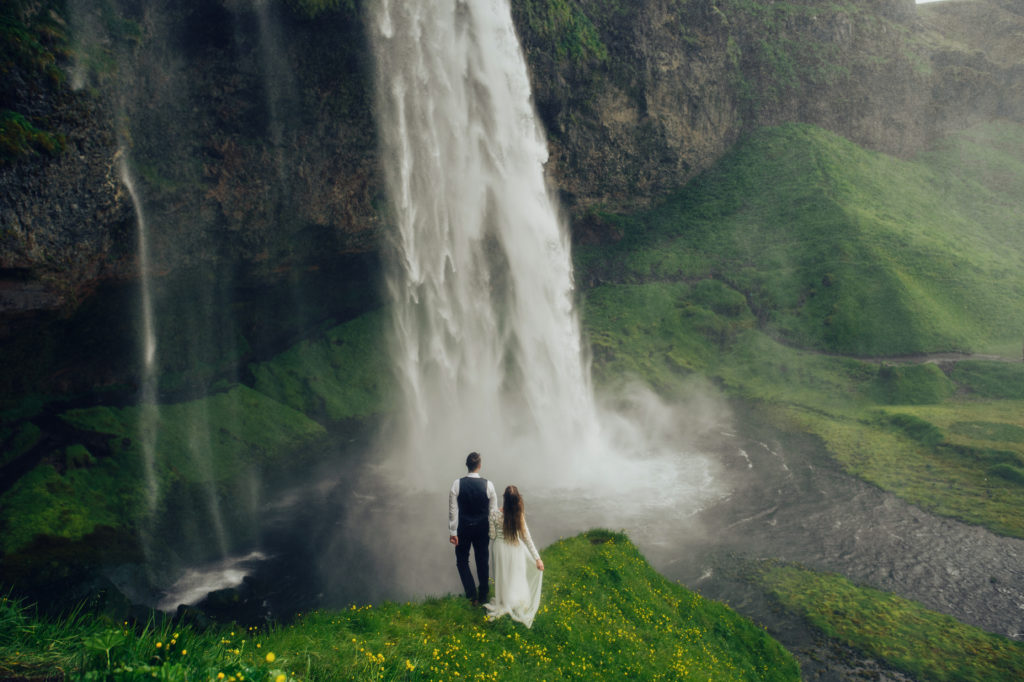 top elopement location trends of 2022, Iceland Elopement. Happy stylish smiling couple walking and kissing in Iceland , on their wedding day.