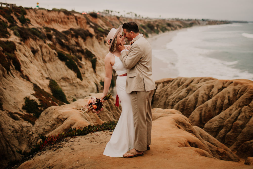 Moody Carlsbad Cliffs Adventure Session. The little beach town of Carlsbad is exploding with boutique shops, great beach life, and lots of tasty restaurants. It's one of our very favorite west coast elopement spots and you'll see why with this moody Carlsbad Cliffs adventure session!