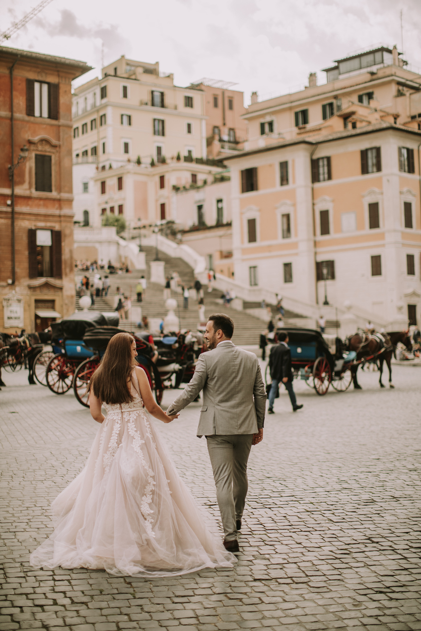 How to elope in Italy. Loving wedding couple near Spanish steps (Scalinata di TrinitÃ  dei Monti) in Rome, Italy.