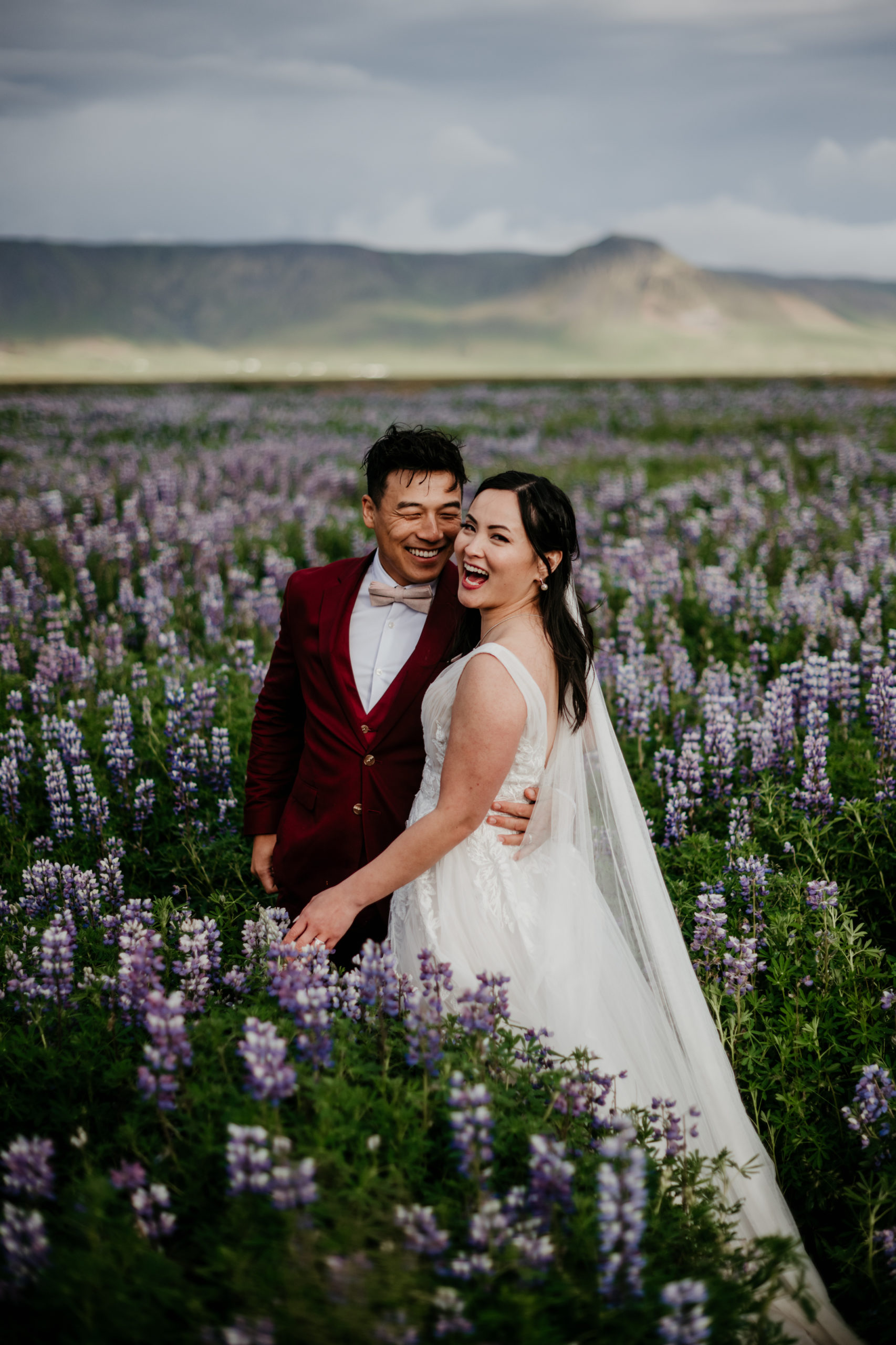 Lupine fields wedding photos! During their Iceland elopement at Reynisfjara, a bride and groom explored the lupine fields of Iceland. Iceland is a one of a kind and adventurous elopement location and MUST be explored! If you're wondering how to elope in Iceland, see how these two did it! 