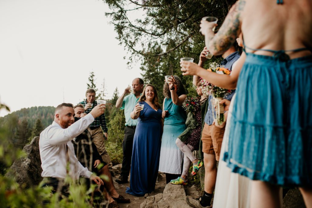 Couple on a micro wedding hike cheersing to the happy couple.