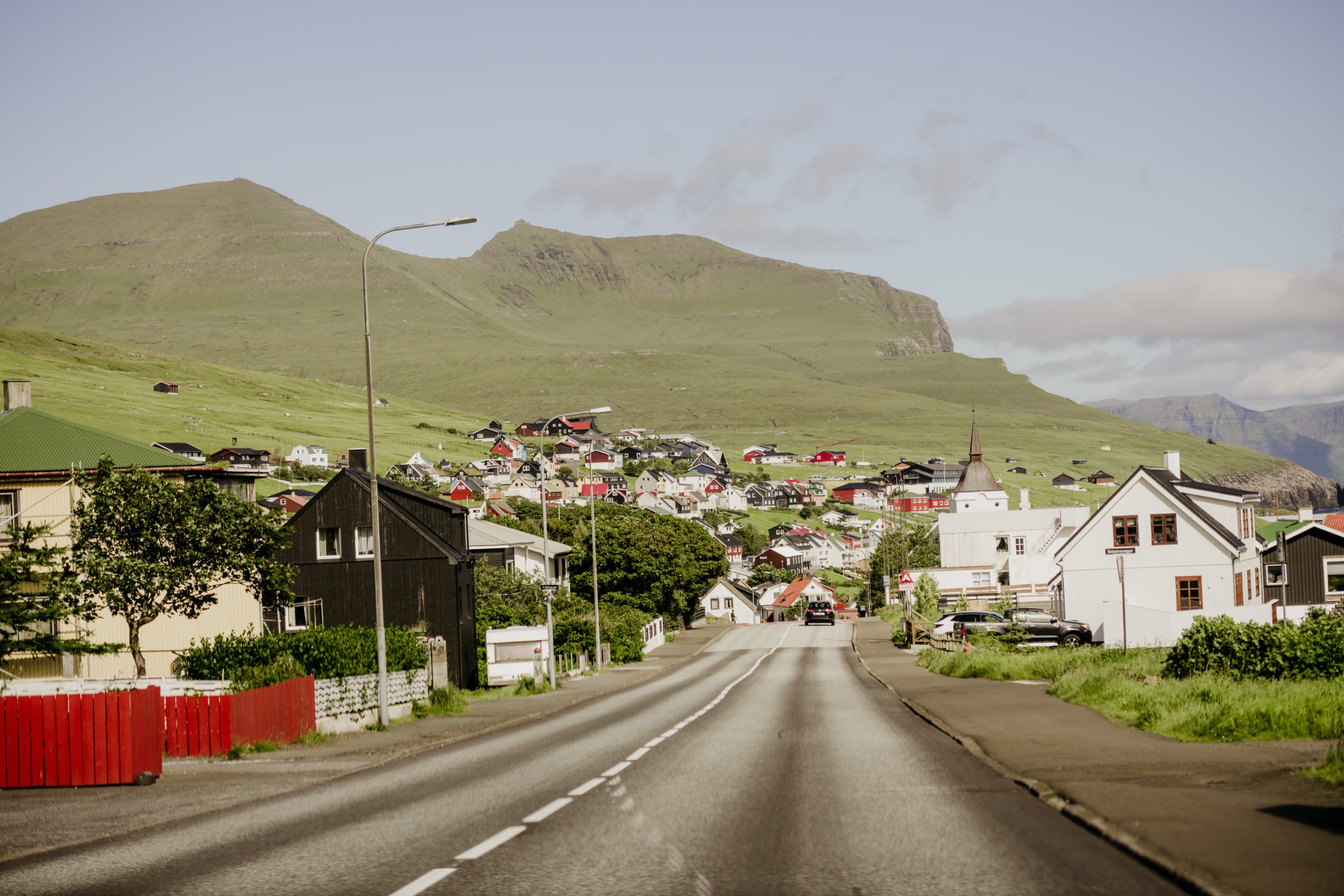 How to elope in Faroe Islands. The village Sandavágur is situated on Vágar island. red roof church in Sandavagur. 