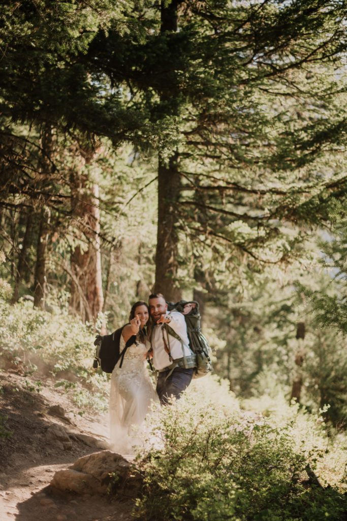 Have an eco friendly elopement by following these tips for conscious tourism.

Hiking elopement couple hike with their wedding clothes and backpack. 