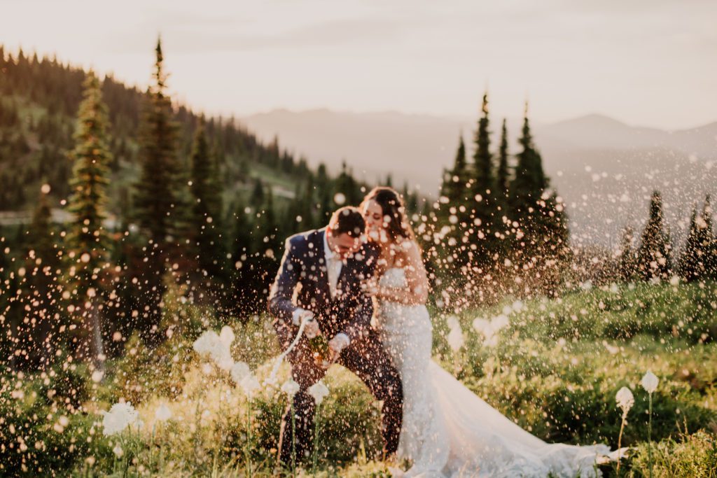 Best of 2022 elopement & wedding photography, Montana wedding at Whitefish Resort, Ski resort wedding. Montana wedding photographer. Champagne photo of bride and groom at sunset.