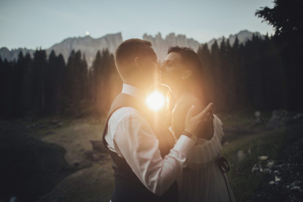 Happy stylish couple in summer alpine meadows in Italy. Kissing bride and groom. Eloping in a foreign country is overwhelming! Americans guide to eloping in Italy to share our REAL plans for our Summer 2023 elopement!