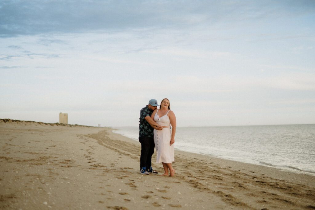 Top Elopement Destinations, Mexico. Couple on the beach with man kissing the woman's shoulder. 