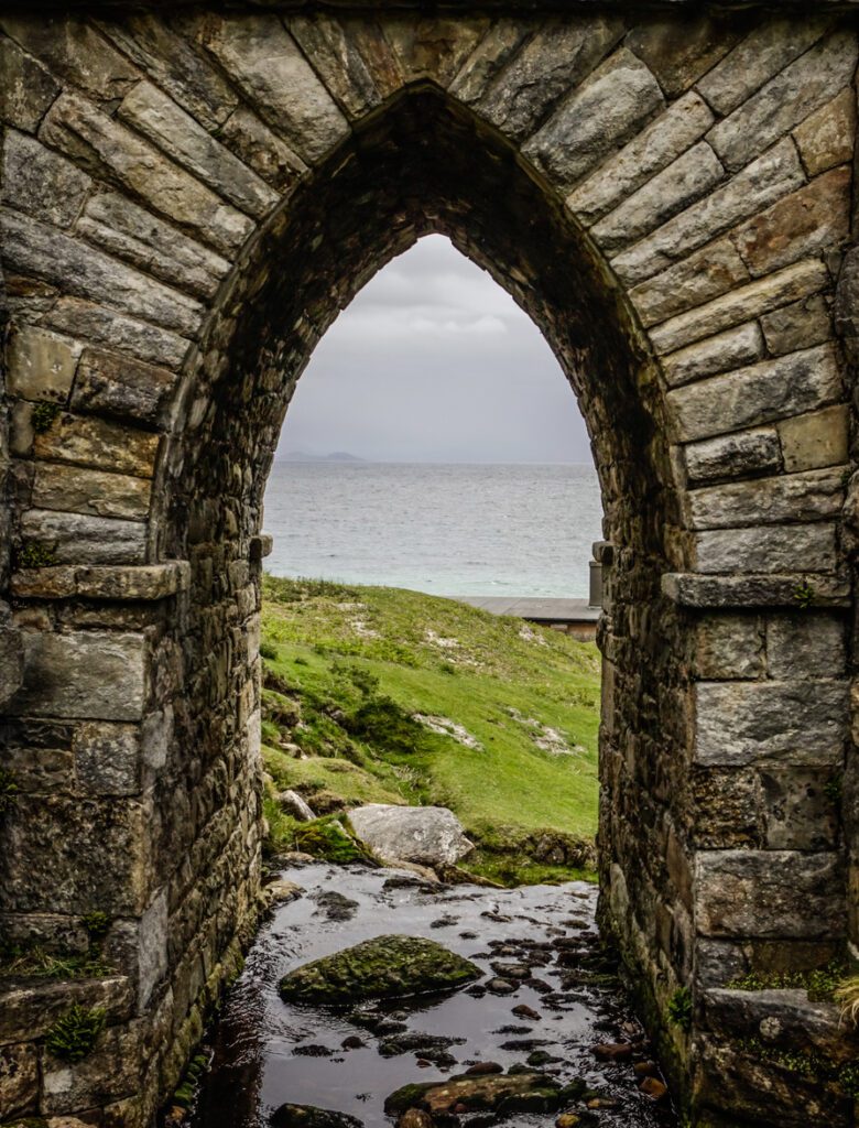 Atlantic ocean seen through the gap in an arch, under the road to Keem beach, on Achill Island, Ireland.