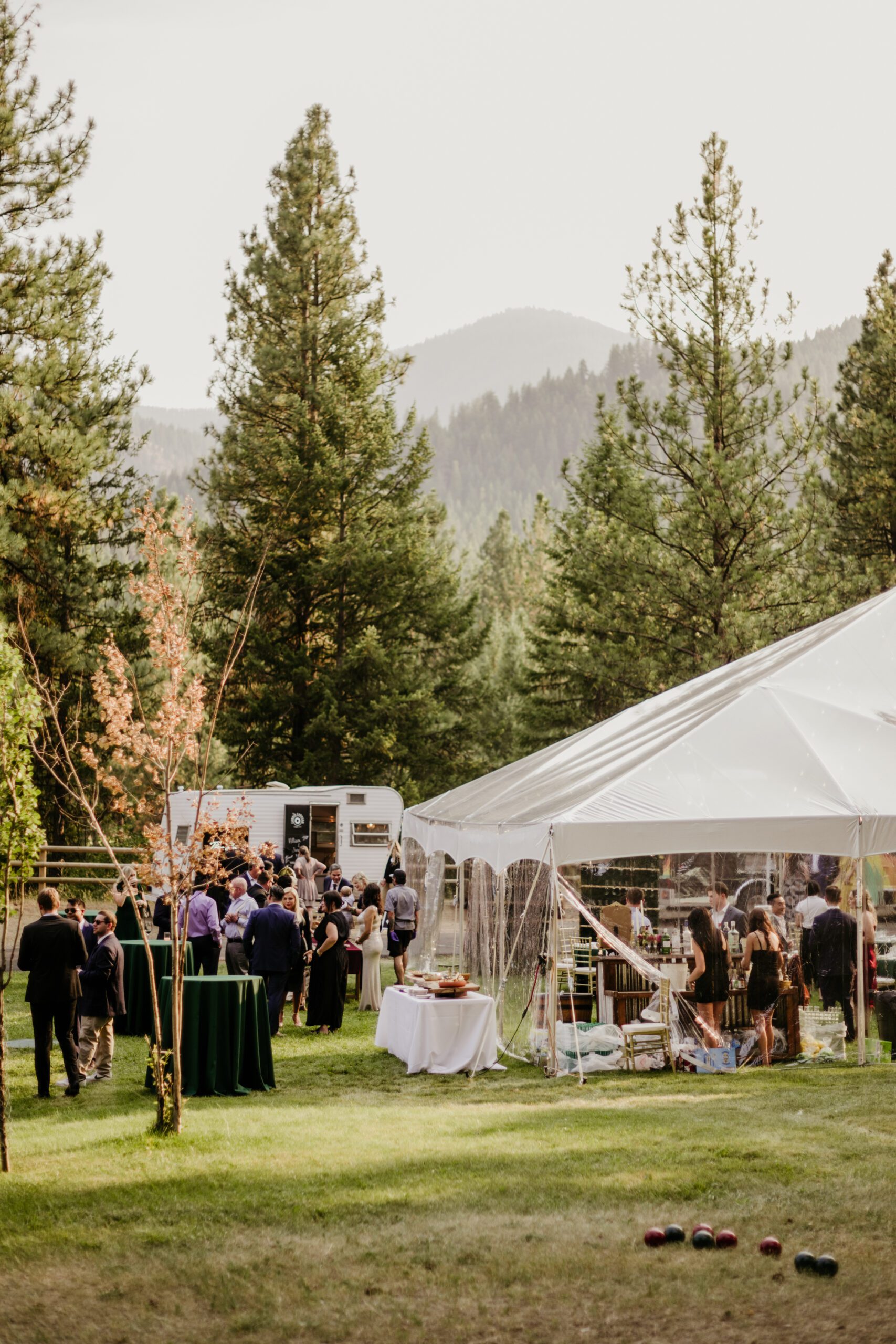 Clear top tent wedding in the mountains.Western Montana luxury wedding.  Emerald greens + burgundy details dress up the Montana mountains. Alpine Falls Ranch wedding checks all the boxes for a destination wedding.