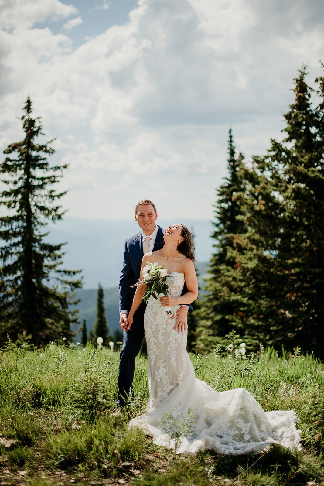 Elope in national park! Husband and wife surrounded by trees. Wife laughing in white wedding dress.