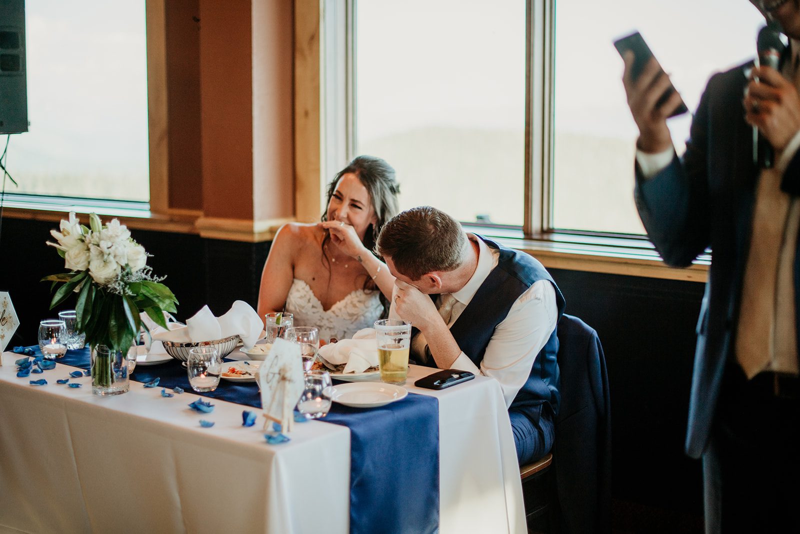 Best wedding destination for foodies, bride and groom laughing at a sweethearts table in Whitefish, Montana.
