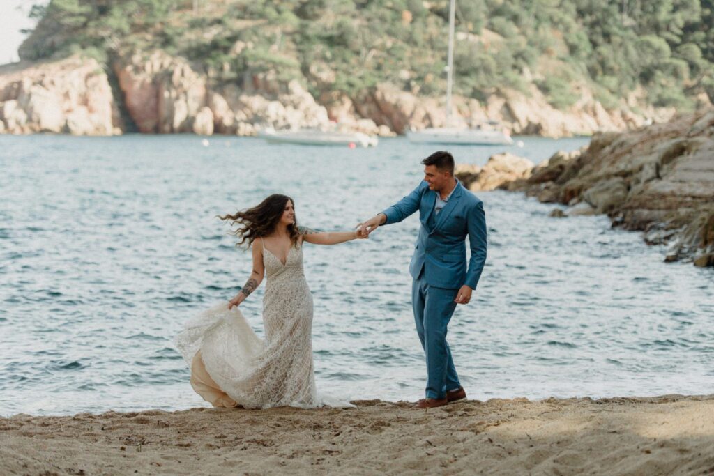 Wedding couple on beach, brown curly hair blowing in the wind. Inspiration for an elopement in Greece.