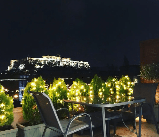 Air BnB photo of Acropolis Suite-Historic Center, night view, romantic table for two to elope in Greece.