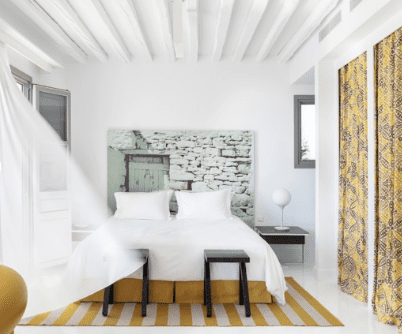 Elope in Greece at the Anemi Hotel and Spa Folegandros, photo of bedroom with orange striped rug