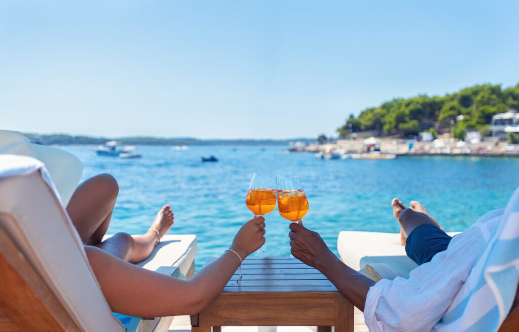 Elope in Greece with current information on Athens, Folegandros, Paros, and Lemnos for 2024 ultimate travel.

Couple celebrating a Greece elopement cheering with a spritz.