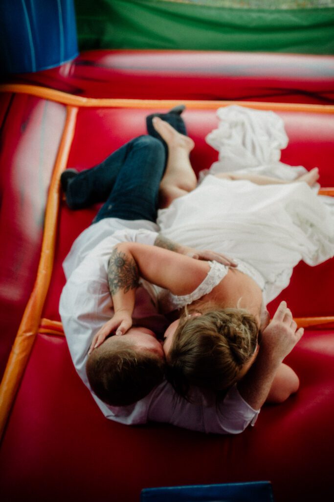 A stunning Little Smith Creek Ranch wedding in the Bitterroot Valley with breathtaking views, heartfelt moments, and a charming rustic theme. Bride and groom in bouncy house on wedding day.