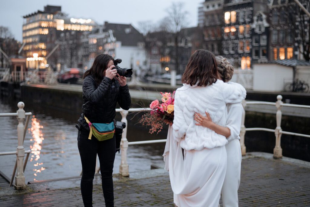 Make the shift to elopement photography! elopement photographer capturing lesbian elopement in Amsterdam with the canal behind. 