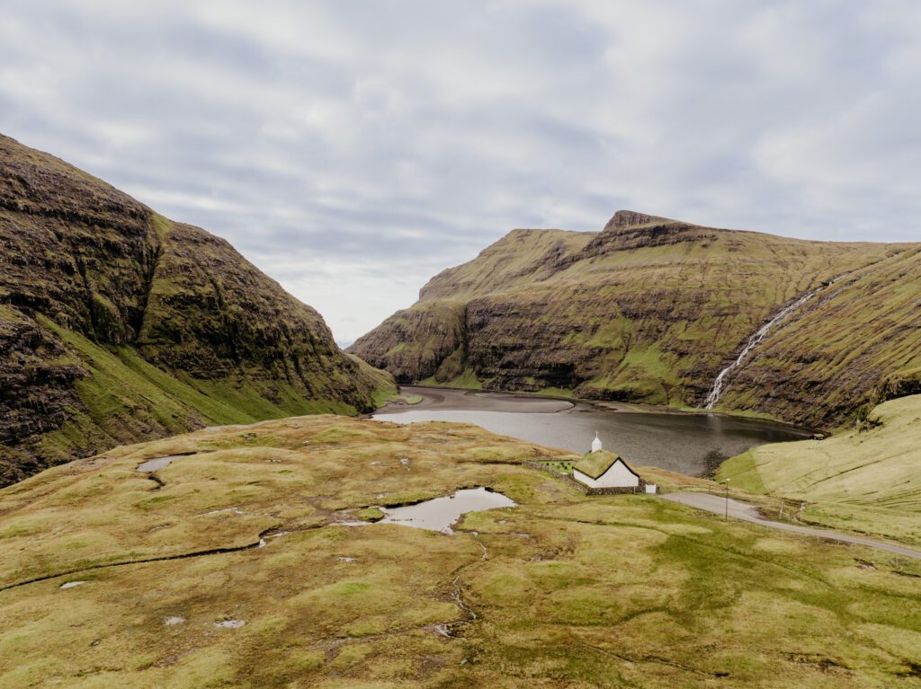 An unforgettable Faroe Islands elopement! Spontaneous vows, stunning cliffs, local traditions and stormy star photos at Saksun. Drone photo of Saksun.