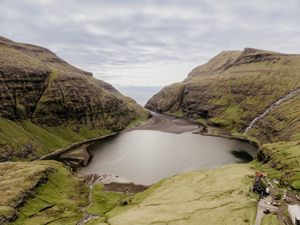 An unforgettable Faroe Islands elopement! Spontaneous vows, stunning cliffs, local traditions and stormy star photos at Saksun. Drone photo of Saksun.