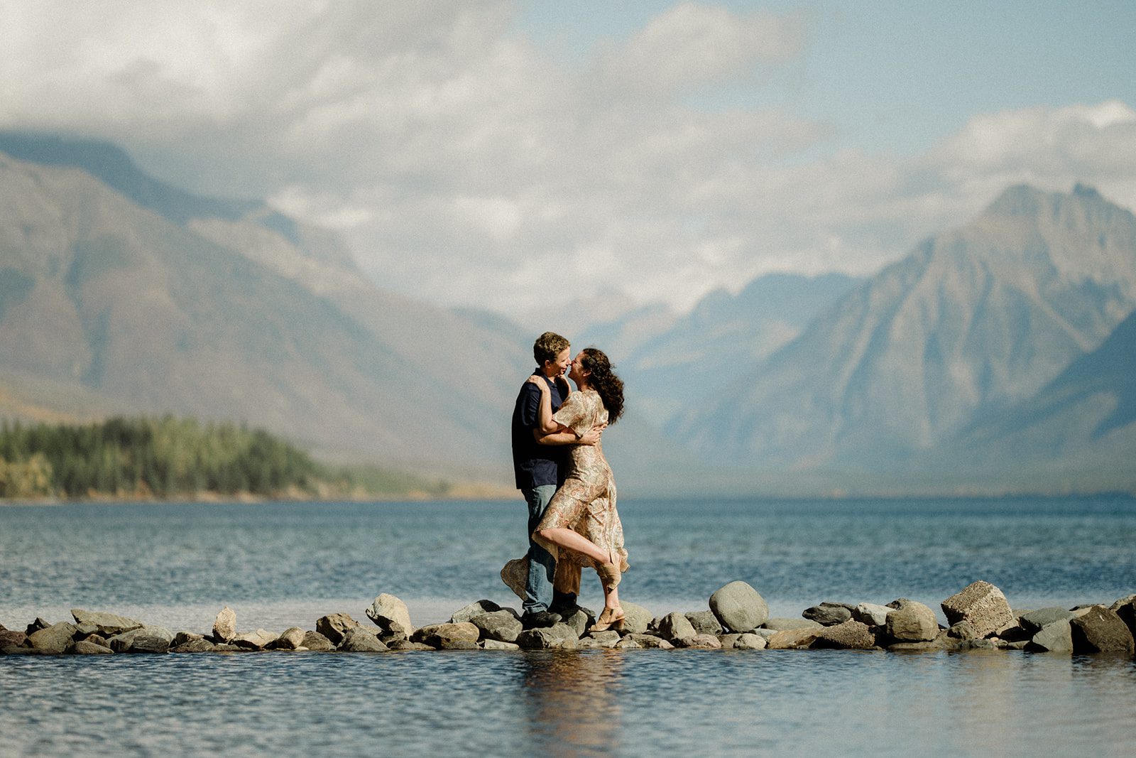 Montana Vow Renewal. Couple walking across the rocks with mountains in the background at Glacier National Park.