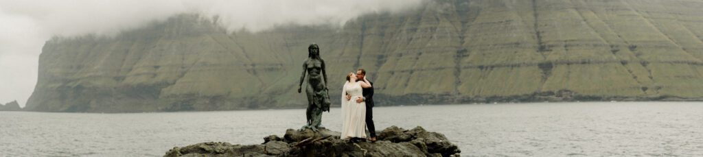 An unforgettable Faroe Islands elopement! Spontaneous vows, stunning cliffs, local traditions and stormy star photos at Saksun. Wedding ceremony at the Sea Woman statue in Kalsoy. 