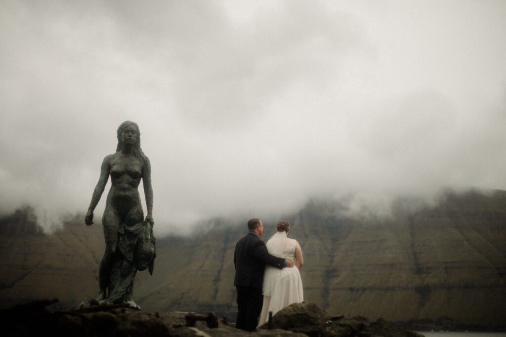 An unforgettable Faroe Islands elopement! Spontaneous vows, stunning cliffs, local traditions and stormy star photos at Saksun. Wedding ceremony at the Sea Woman statue in Kalsoy. 