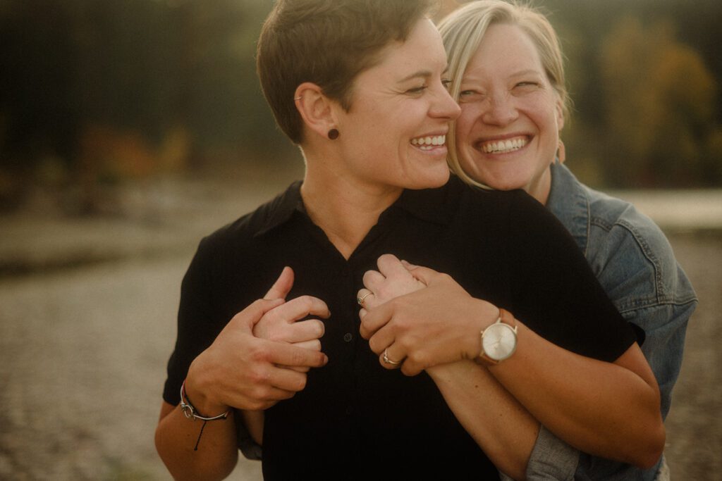 Lesbian couple in Missoula Montana, smiling together after getting engaged.