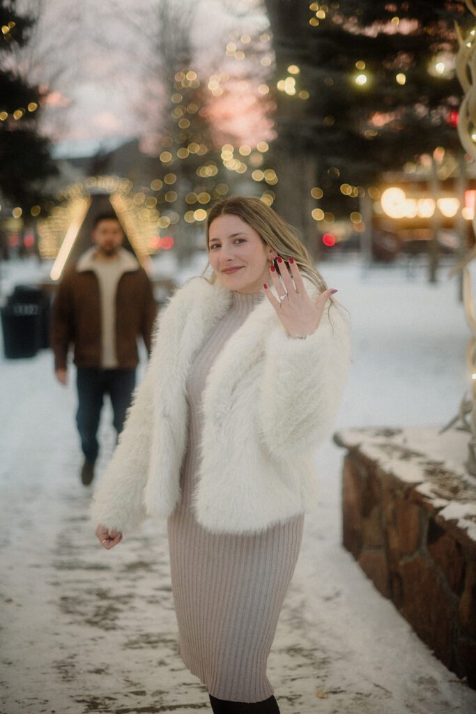 Proposal in Grand Teton. New fiance shows off her ring, husband to be stands behind her slightly blurred. 