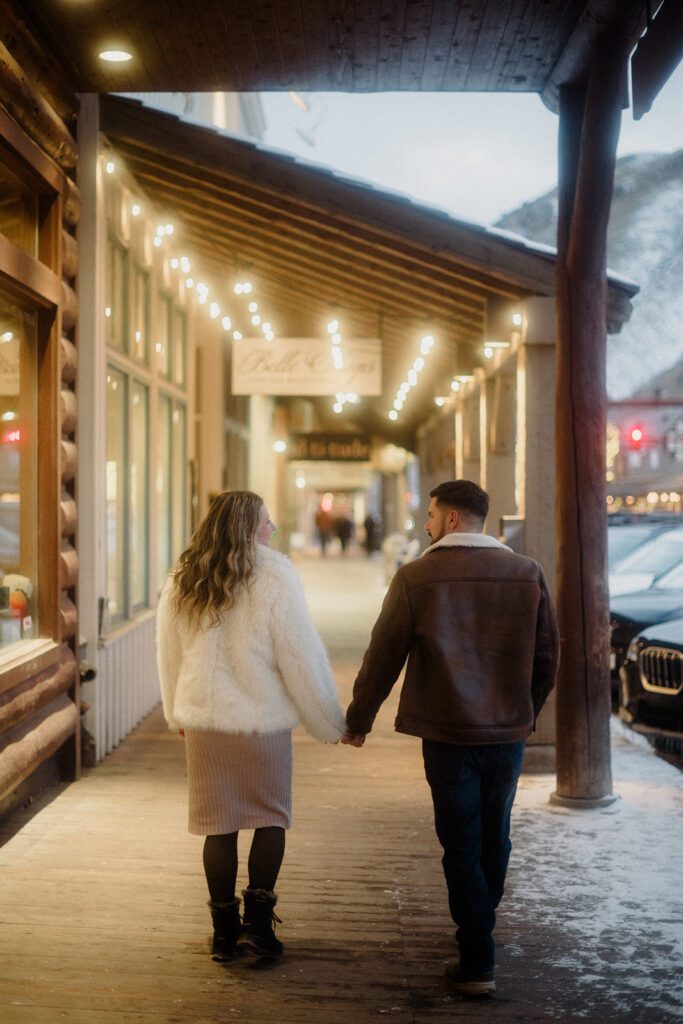 Proposal in Grand Teton. Man and woman walking Downtown together, hand in hand during the evening glow.
