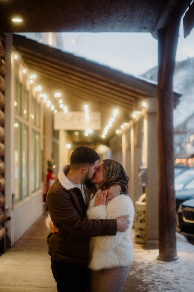 Proposal in Grand Teton. Man and woman embracing during Downtown stroll together.