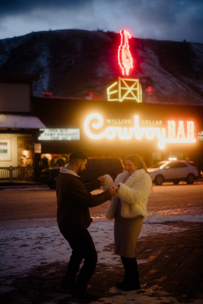 Proposal in Grand Teton. Couple celebrating after outside the Country Bar in Jackson Hole, Wyoming.