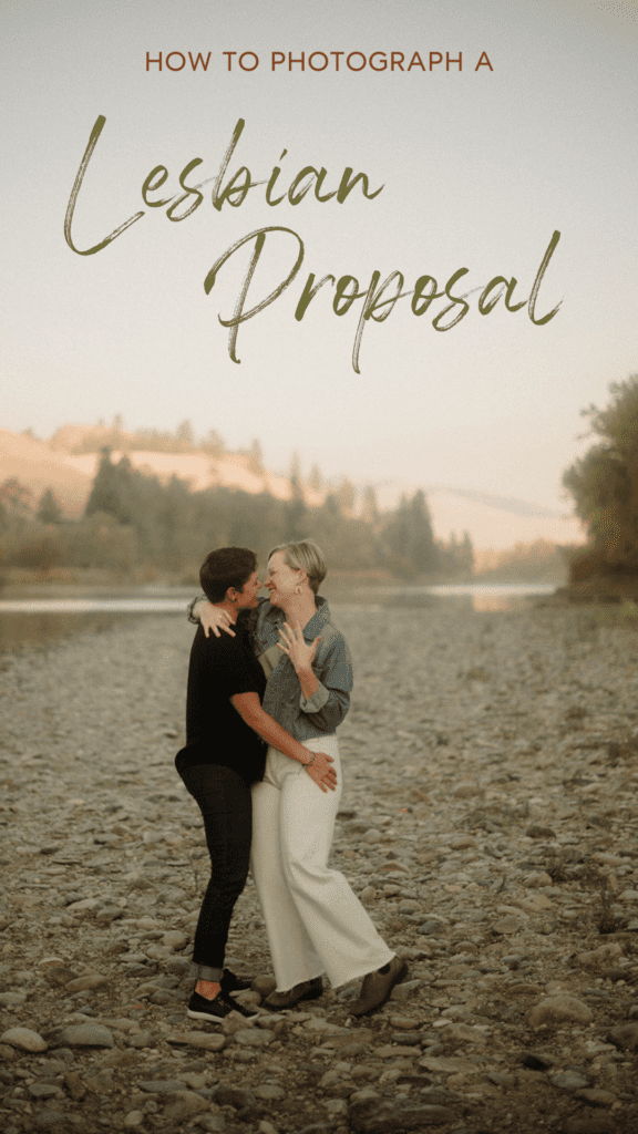 Lesbian Proposal in Missoula: Maclay Flat in Autumn. Woman showing off her engagement ring while lesbian partner holds her close. Women on rocky shoreline with water and trees behind them.