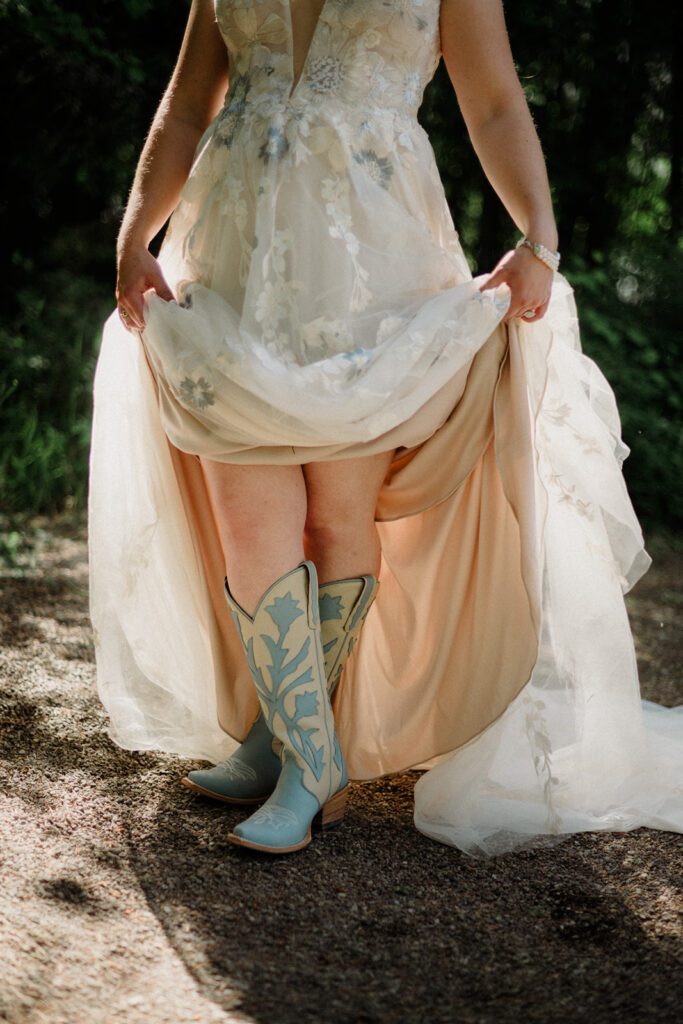 Bride raising dress to show baby blue cowboy boots in Glacier National Park.