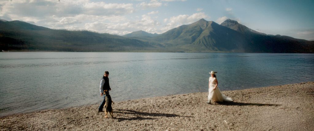 How to have a micro wedding in Glacier National Park with 30 friends and family. Couple walking along the shores of Lake McDonald