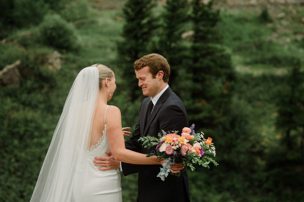 Groom holding bride and crying on wedding day.