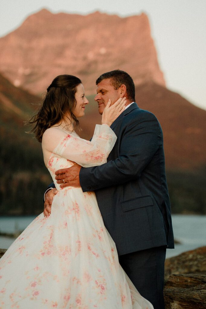 Sun Point Micro Wedding sunrise photo of bride and groom kissing with water behind them.