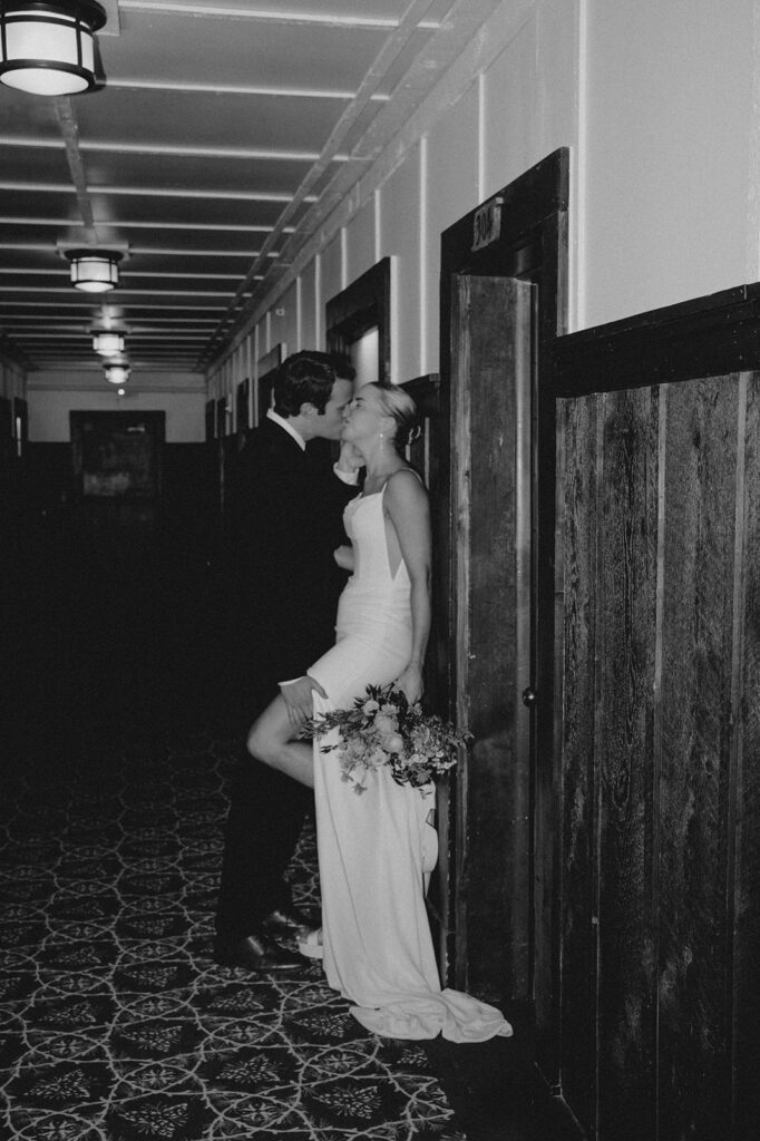 Wedding couple in Many Glacier Hotel, shows grooms hand on bride's thigh. No faces shown. 