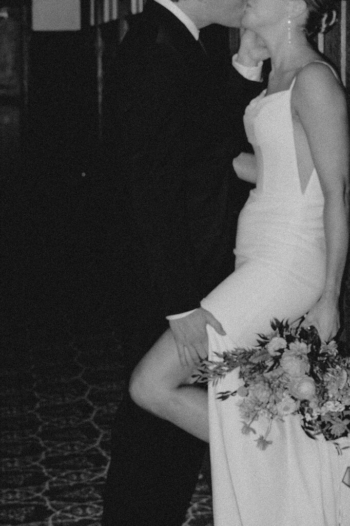 Wedding couple in Many Glacier Hotel, shows grooms hand on bride's thigh. No faces shown. 