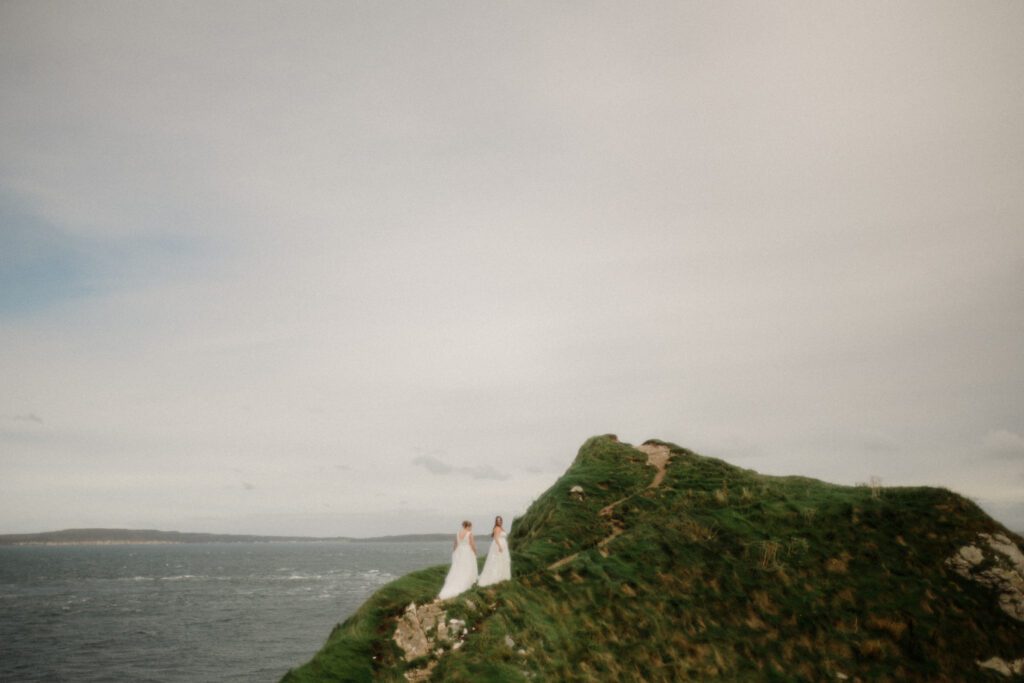 Northern Ireland elopement with epic locations like Kinbane Castle, Ballintoy Harbor and Giant's Causeway! LGBTQ+ wedding photographer takes Debbie & Kirstie on an epic adventure in Northern Ireland!