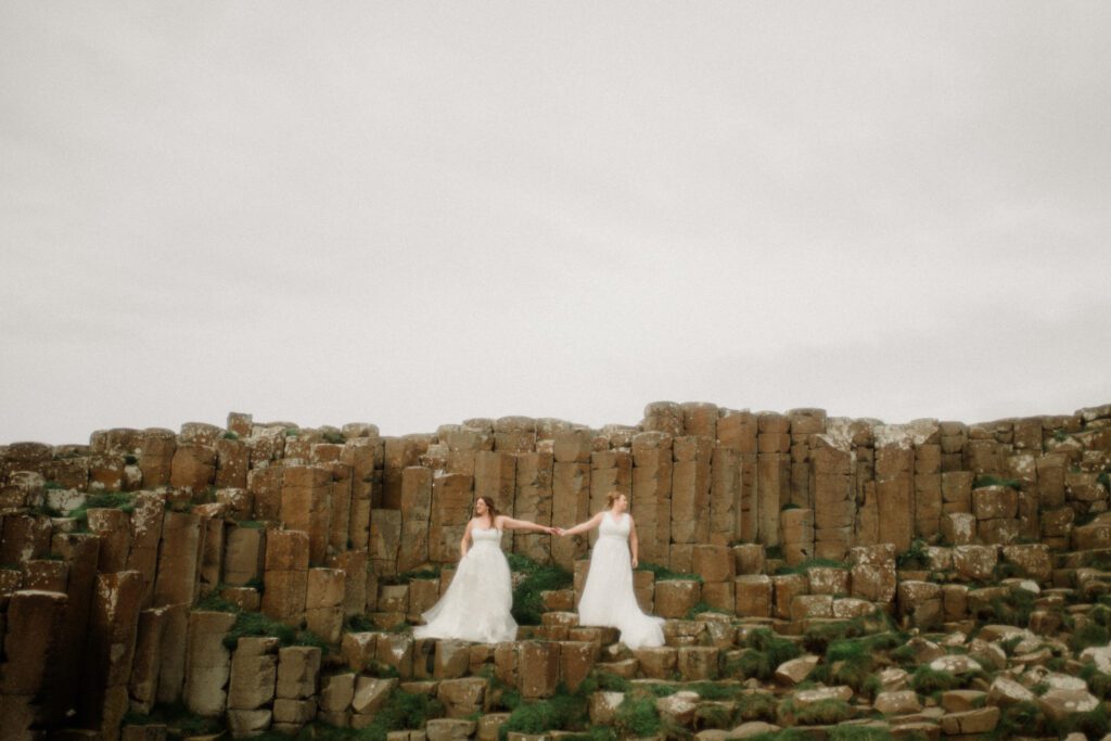 Northern Ireland elopement with epic locations like Kinbane Castle, Ballintoy Harbor and Giant's Causeway! LGBTQ+ wedding photographer takes Debbie & Kirstie on an epic adventure in Northern Ireland!