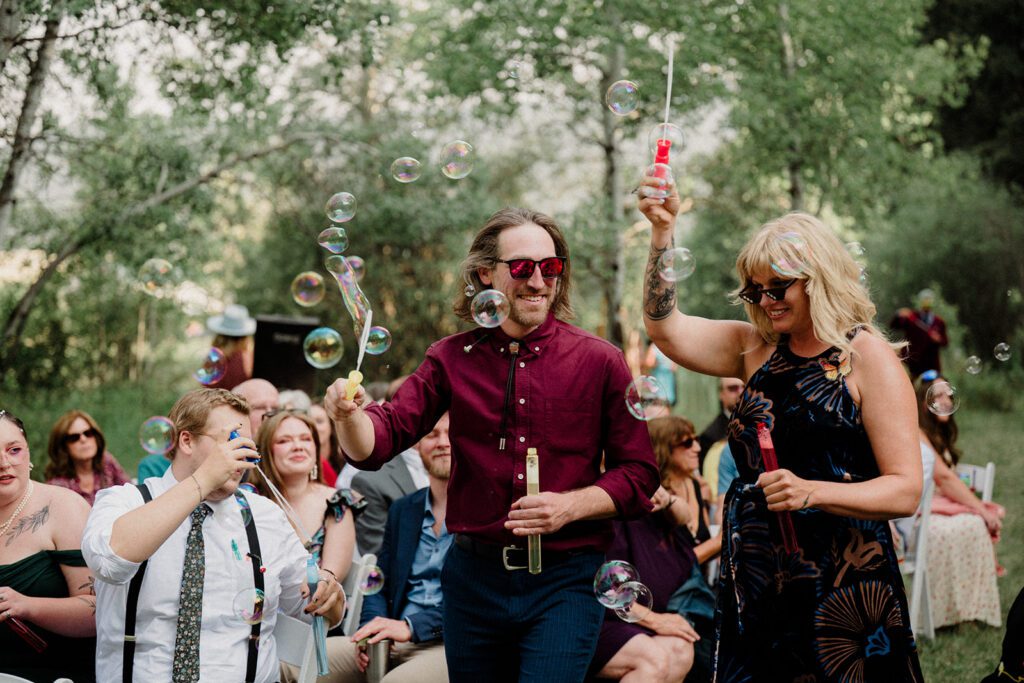 A fun non-traditional wedding in Bozeman with flower baskets, pizza, a “gaggle” wedding party, and sunset photos. See how this couple rewrote the rules.