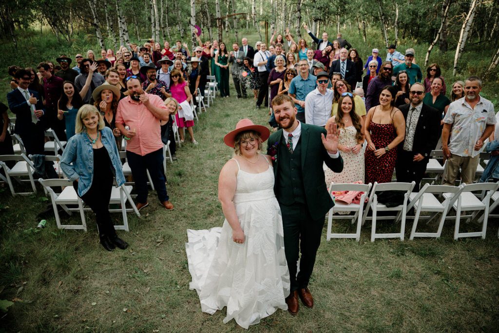 A fun non-traditional wedding in Bozeman with flower baskets, pizza, a “gaggle” wedding party, and sunset photos. See how this couple rewrote the rules.